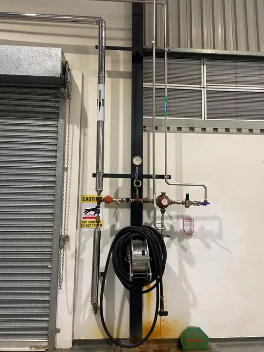 Wall-mounted service line with a gauge, valve and hose reel